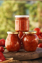 Three jars of homemade tomato and sweet pepper relish (ajvar-style vegetable spread, chutney or bruschetta topping)