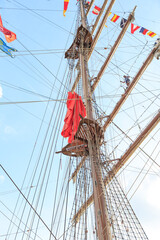 Looking up the wooden mast against the blue sky