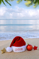 New Year 2026 background with red Santa Claus Hat on Caribbean beach.