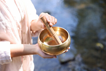 Woman with singing bowl in nature, closeup