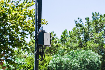 Electrical box with bundles of cables on a utility pole. Outdoor street infrastructure and communication system equipment.