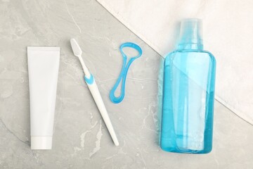 Mouthwash and other oral hygiene products on light marble table, flat lay