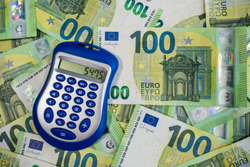 Stack of Euro banknotes with blue calculator symbolizing finance, accounting and money planning