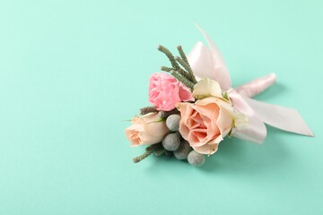 Boutonniere with beautiful flowers on turquoise background, closeup. Space for text