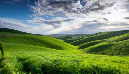 Obraz premium Lush Green Rolling Hills Under A Partially Cloudy Sky In A Serene Landscape During Midday