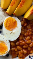 Hearty homemade breakfast with egg, beans in tomato sauce with smoked paprika, nectarine and cheese toast, protein rich meal in natural light