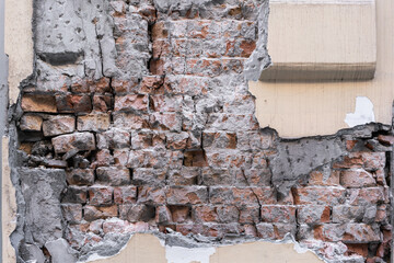 An old broken or destroyed wall with plaster and bricks. Grange background for designers.