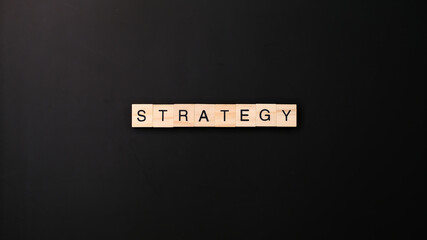 STRATEGY spelled with wooden letter on black background