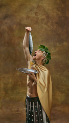 Man in golden toga with laurel crown holding fish in humorous feast scene. Concept of food...