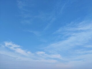 clear blue sky with a few clouds. The sky is very bright and the clouds are scattered throughout