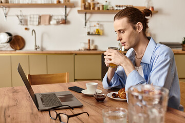 Enjoying a serene morning tea, a young handsome man reflects while working at home