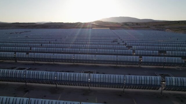Solar thermal power plant with parabolic mirrors in a dry landscape. Renewable energy technology for clean electricity production and environmental sustainability.