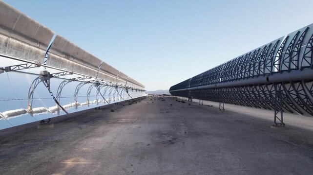 Solar thermal power plant with parabolic mirrors in a dry landscape. Renewable energy technology for clean electricity production and environmental sustainability.