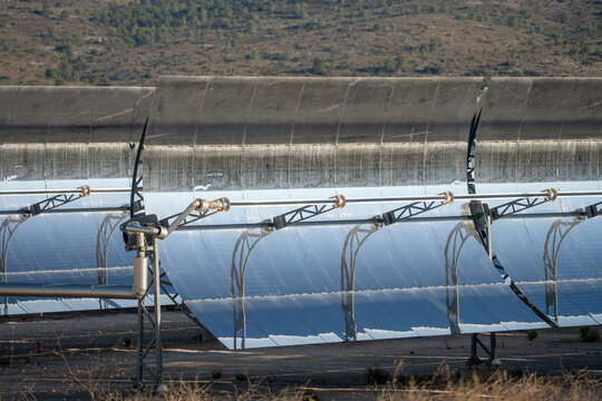 Solar thermal power station with rows of parabolic trough mirrors reflecting sunlight. Renewable energy facility showcases cutting-edge technology for sustainable electricity generation.