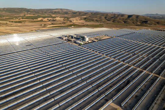 Solar thermal power station with rows of parabolic trough mirrors reflecting sunlight. Renewable energy facility showcases cutting-edge technology for sustainable electricity generation.