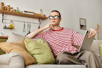 Obraz premium Charming young man enjoys a cozy afternoon while contemplating on the couch