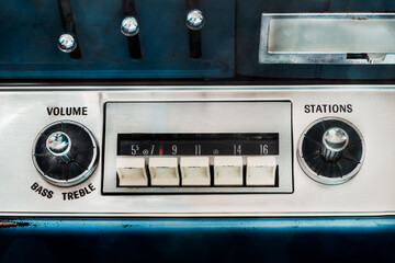 Retro styled image of an old car radio inside a blue classic American car