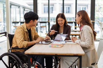 Group of business people in a meeting with man on a wheelchair for inclusion. Young businessman greeting business partner and team. Coworker on wheelchair
