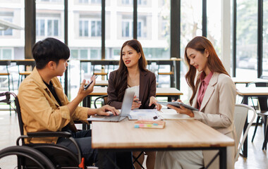 Group of business people in a meeting with man on a wheelchair for inclusion. Young businessman greeting business partner and team. Coworker on wheelchair
