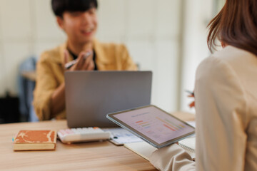 Obraz premium Group of business people in a meeting with man on a wheelchair for inclusion. Young businessman greeting business partner and team. Coworker on wheelchair 