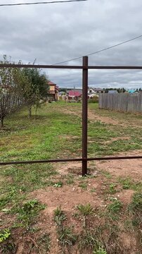 Black or brown metal fence posts. Posts and and lintels. Unfinished fence. Vertical