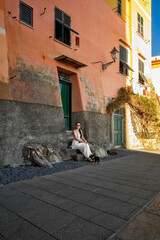 Momento di quiete a Camogli: donna con cane su panchina tra colori e luce mediterranea