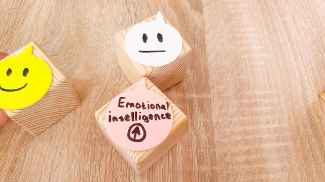 EMOTIONAL INTELLIGENCE text, inscription with drawn emoticons and emotions on cubes. Psychological health, concept.
