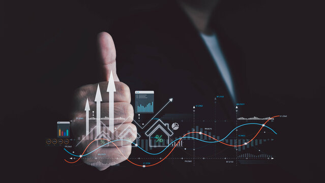 Person in black suit giving thumbs-up with overlay of digital financial graphs, upward arrows, and house icon. Concept of successful real estate investment and financial growth.