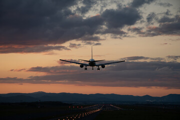 夕暮れの飛行場に着陸するジェット機
