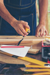 Vertical Horizon DIY craftsperson asian man working wood heap carpenter objects woodwork desk. Vertical Architect man hands use ruler measure hammer home improvement. Wooden builder carpenter