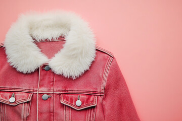 Closeup of a chic red denim jacket with a luxurious white faux fur collar, perfect for adding a touch of cozy elegance to any outfit
