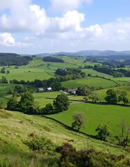 Lush green valley landscape under a partly cloudy sky