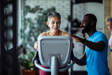 Senior woman exercising with trainer