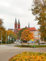Narrow street in Białystok, Poland, with warm autumn colors and a clear view of the main cathedral (St. Roch&rsquo;s Church) in the distance, empty and peaceful city scene.