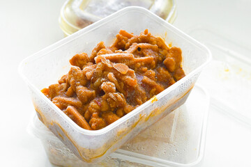 Frozen food in a plastic box container. Sweet chilli chicken leftover. Photo can be used for the concept of is frozen food healthy to eat or how do you keep frozen food fresh.