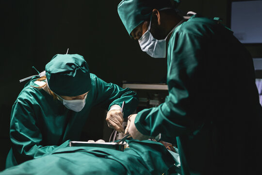 surgeon group using procedure cleaning wound after operating with instruments. medical staff team wearing uniform working with emergency equipment. surgical team using cotton cleaning injured part