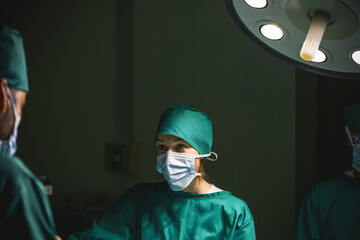 expert surgeon group examine patient body. professional surgical team performing curing operation on patient. medical hospital team wearing uniform helping injured patient in surgery with equipment