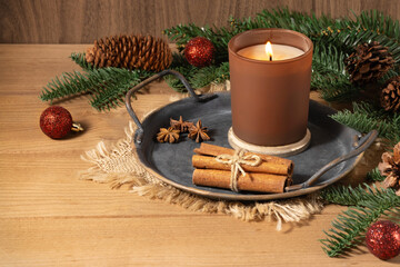 A Christmas arrangement with a candle, fir tree branches, and spices. Cinnamon, anise, candle, fir tree, Christmas decor