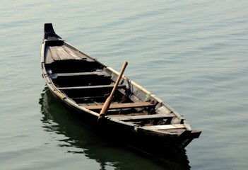 Obraz premium Solitary Wooden Rowboat on Calm Water.