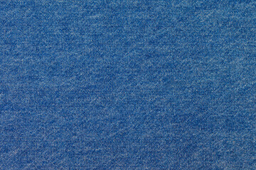 Abstract texture background of classic blue jeans denim fabric. A macro detail showing the distinctive diagonal twill weave and fibers of the material, ideal for fashion and design concepts