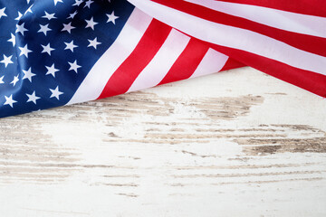 American flag on light wooden background with copy space, perfect for patriotic posters, banners,...