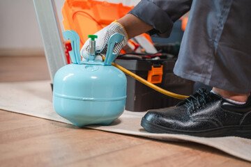 Technician using a blue gas cylinder for maintenance, ensuring safety and precision in work, hands-on approach to tools and equipment, safety gear included