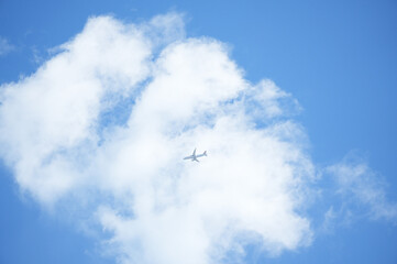Airplane in the blue sky with white clouds, closeup of photo