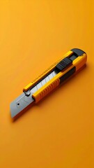 Precision tool stationery knife or box cutter isolated on orange background