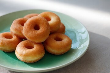 Neatly Arranged Mini Donuts on Green Plate for Soft Daytime Delight