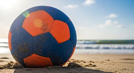 Handball ball rests on sandy beach with tranquil ocean backdrop