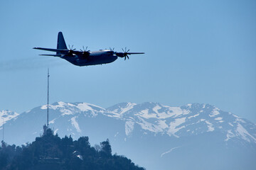 Military airplane in the sky of Santiago, chile with Andes mountains in the background