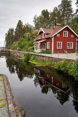 Obraz premium Scenic Red Scandinavian Wooden House Near Dalsland Canal Lock, Sweden