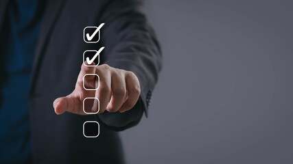 Businessman touching digital checklist with check marks, symbolizing task management, productivity,...