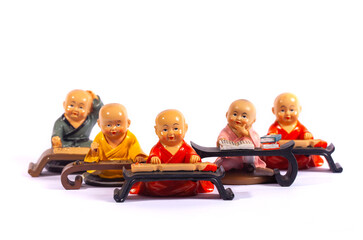 A set of cute figurines depicting young Chinese Buddhist monks studying at their desks. These...